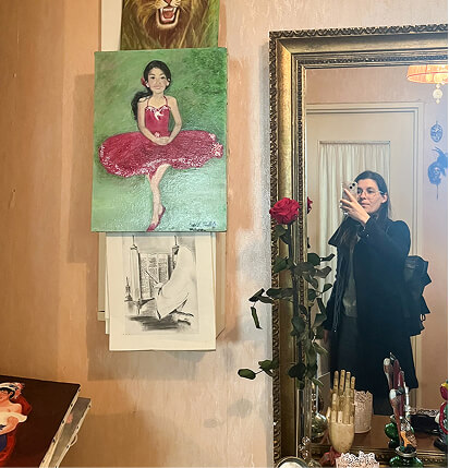 Photo d’une collaboratrice de l’agence là-haut en train de prendre en photo des tableaux décoratifs dans un appartement et son reflet dans un miroir