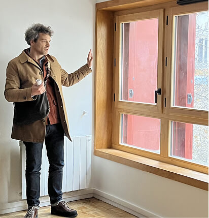 Photo de Tristan Leconte de l’agence là-haut à côté d’une menuiserie d’un appartement du projet de Réhabilitation Plan Climat impasse Delepine