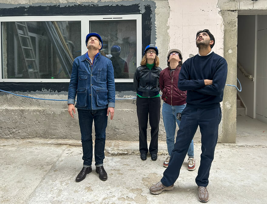 Tristan Leconte et des membres de l'équipe de l'agence là-haut regardent vers le ciel lors d'une visite de chantier.