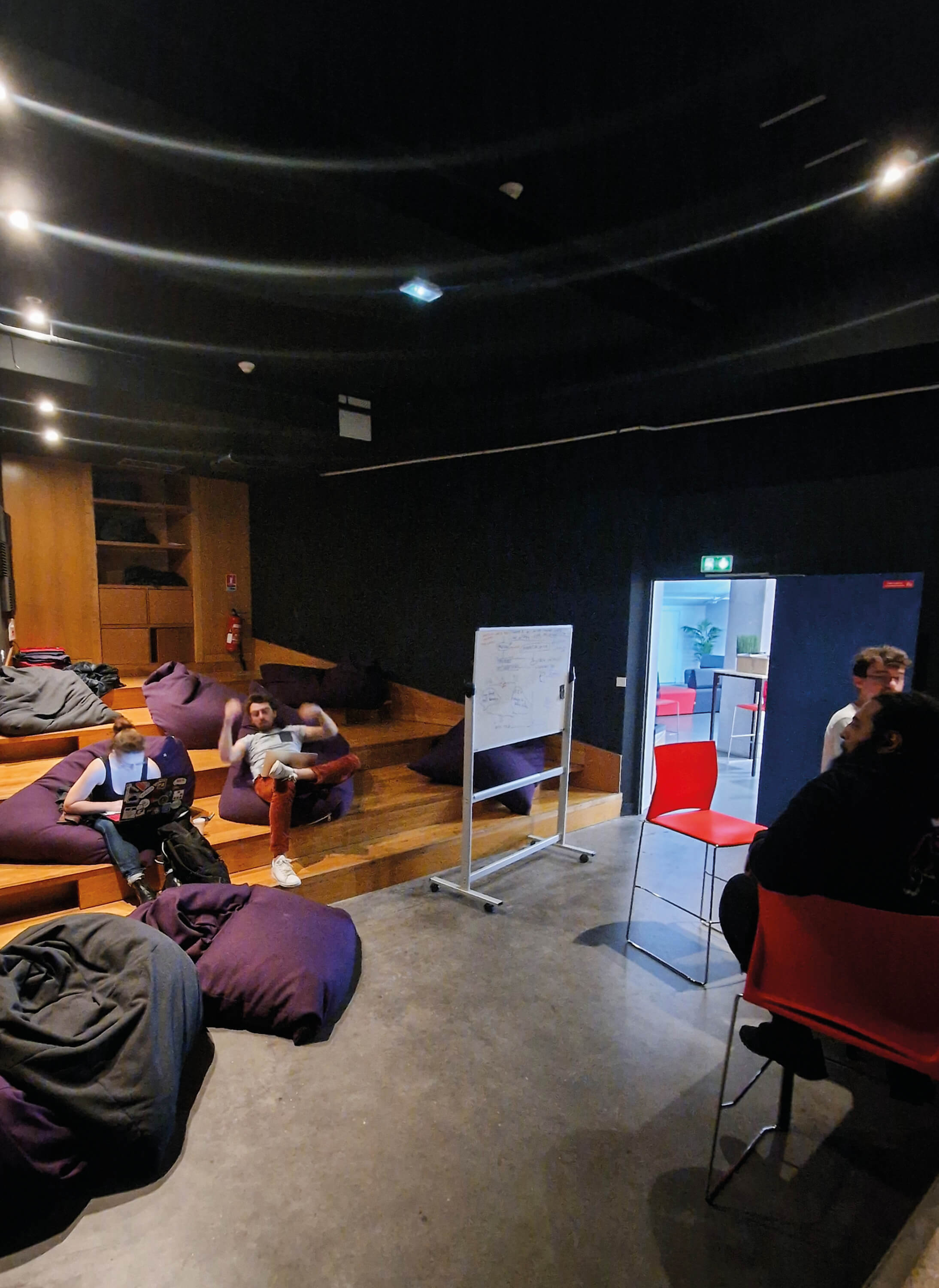 Photo d’élèves sur des poufs géants dans l'espace détente de l’École 2600 créé après la reconversion.
