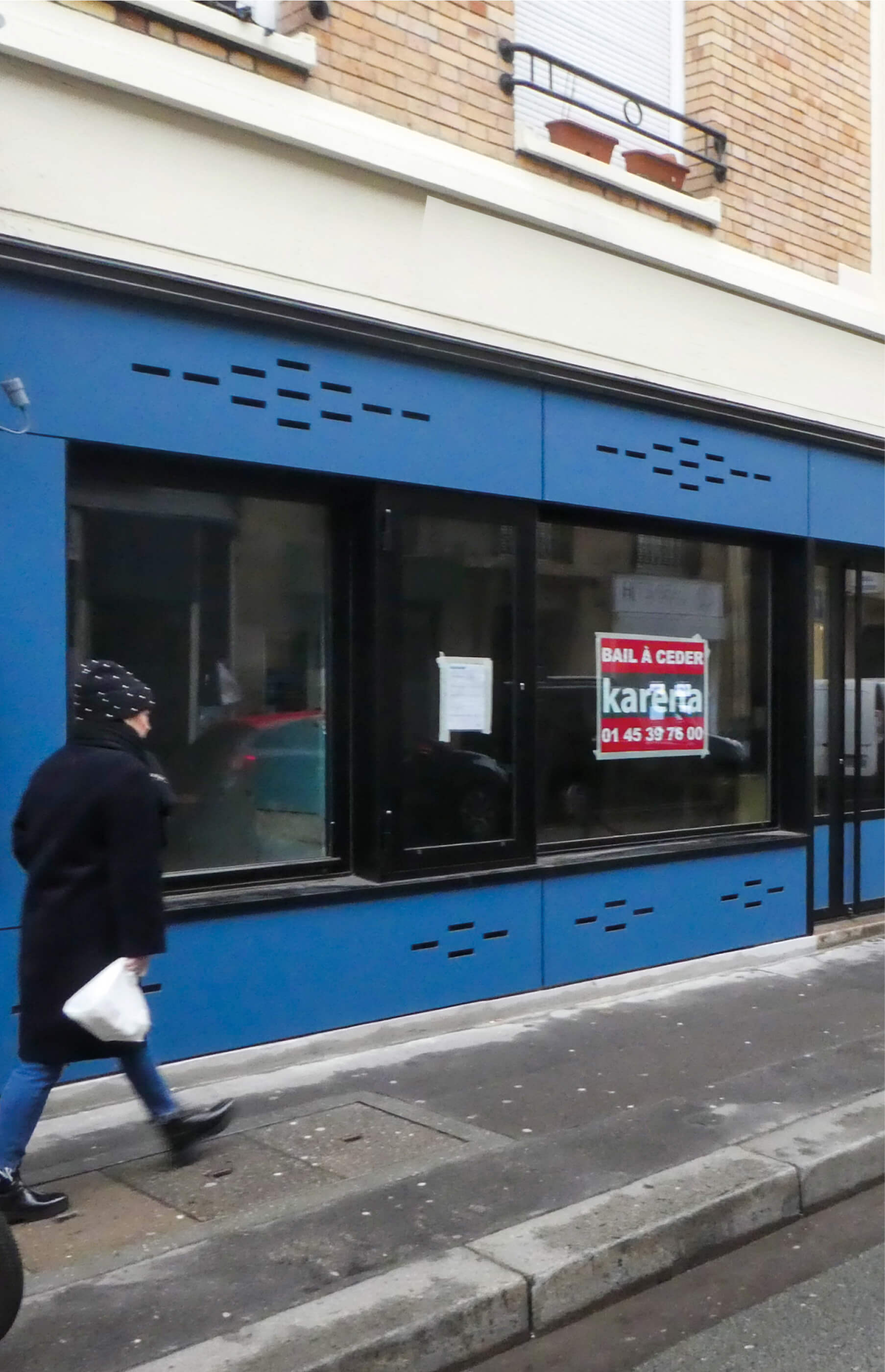 Photo montrant une nouvelle devanture bleue depuis la rue avec un un passant