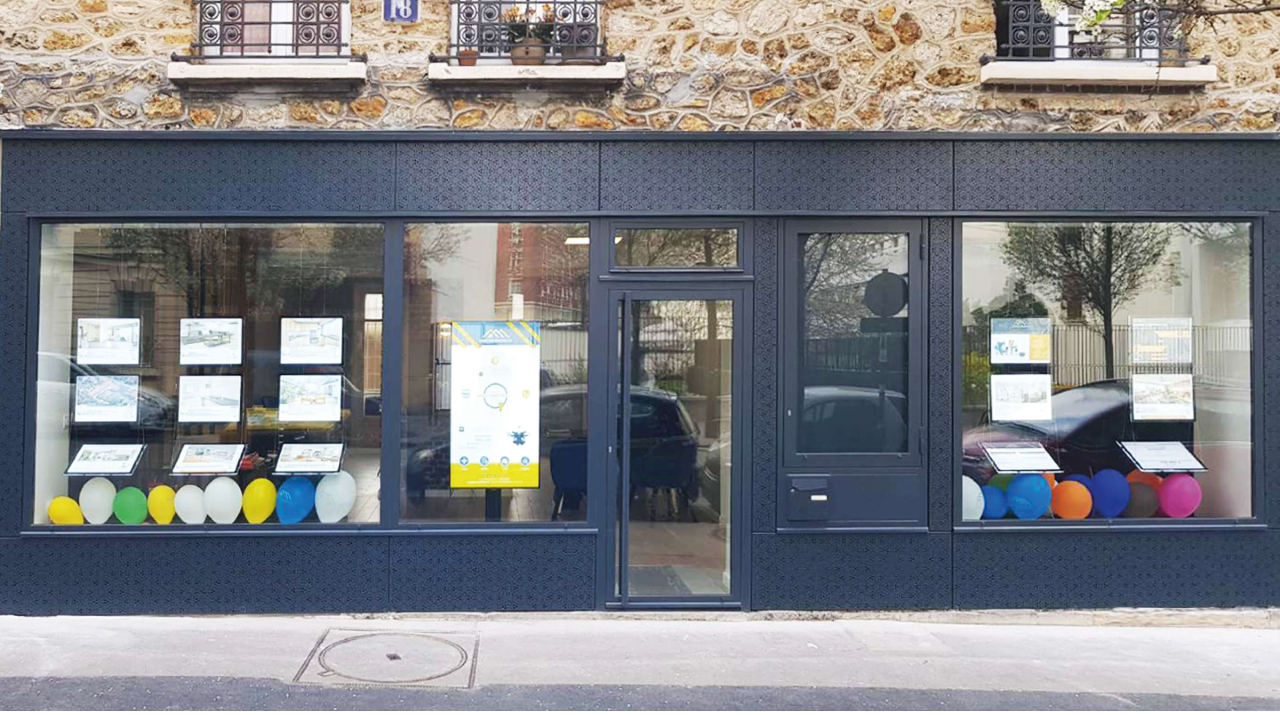 Photo d'une agence immobilier avec ballons dans la vitrine apres remplacement des devantures rues de Cronstadt et Gassendi