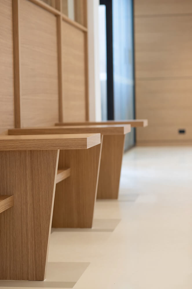 Photo des tablettes en bois installées sur les banquettes de l'Essec après les travaux de restructuration du grand hall.