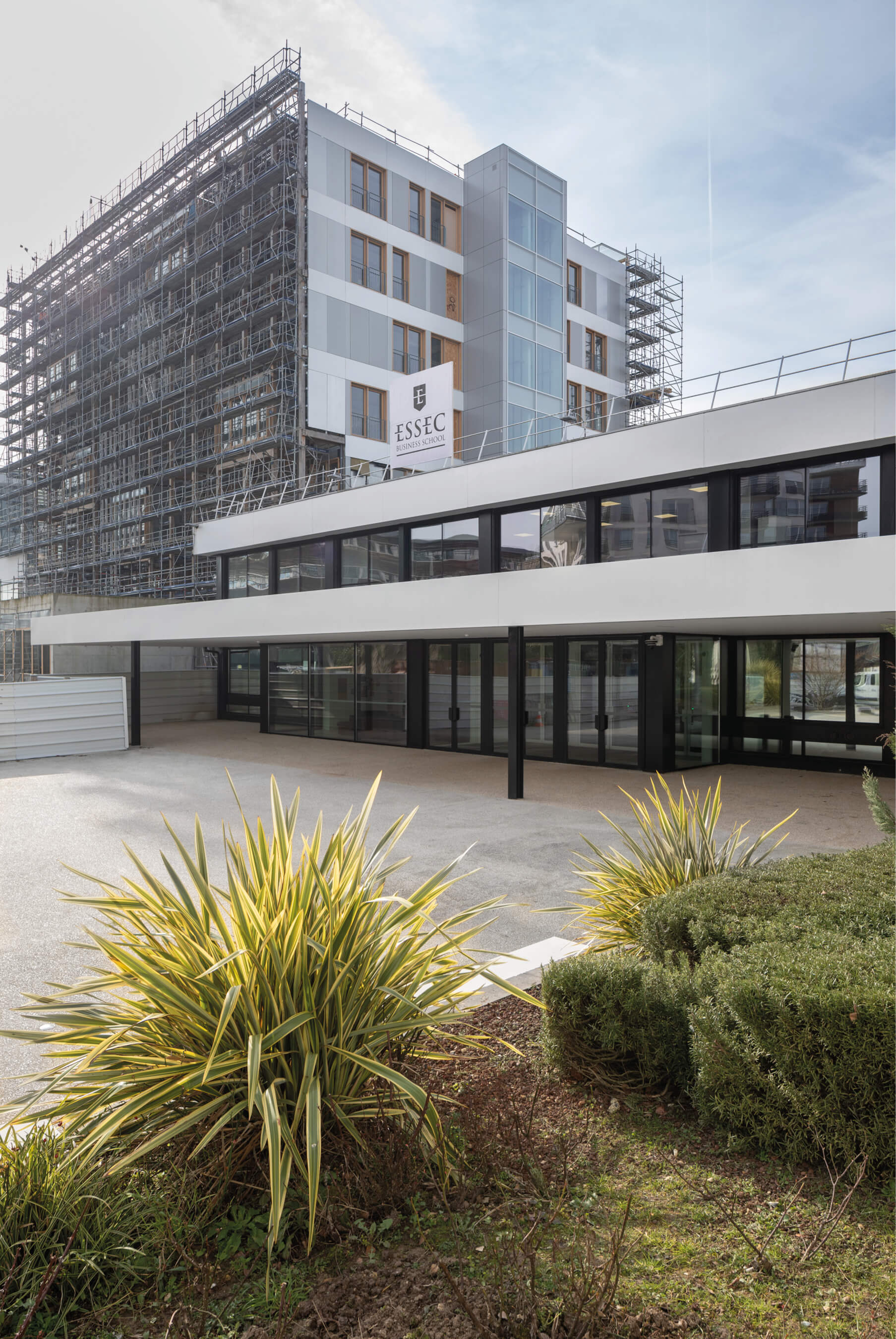 Photo de l'entrée de l'Essec Cergy et de sa tour prise depuis le parvis après les travaux de restructuration du campus.