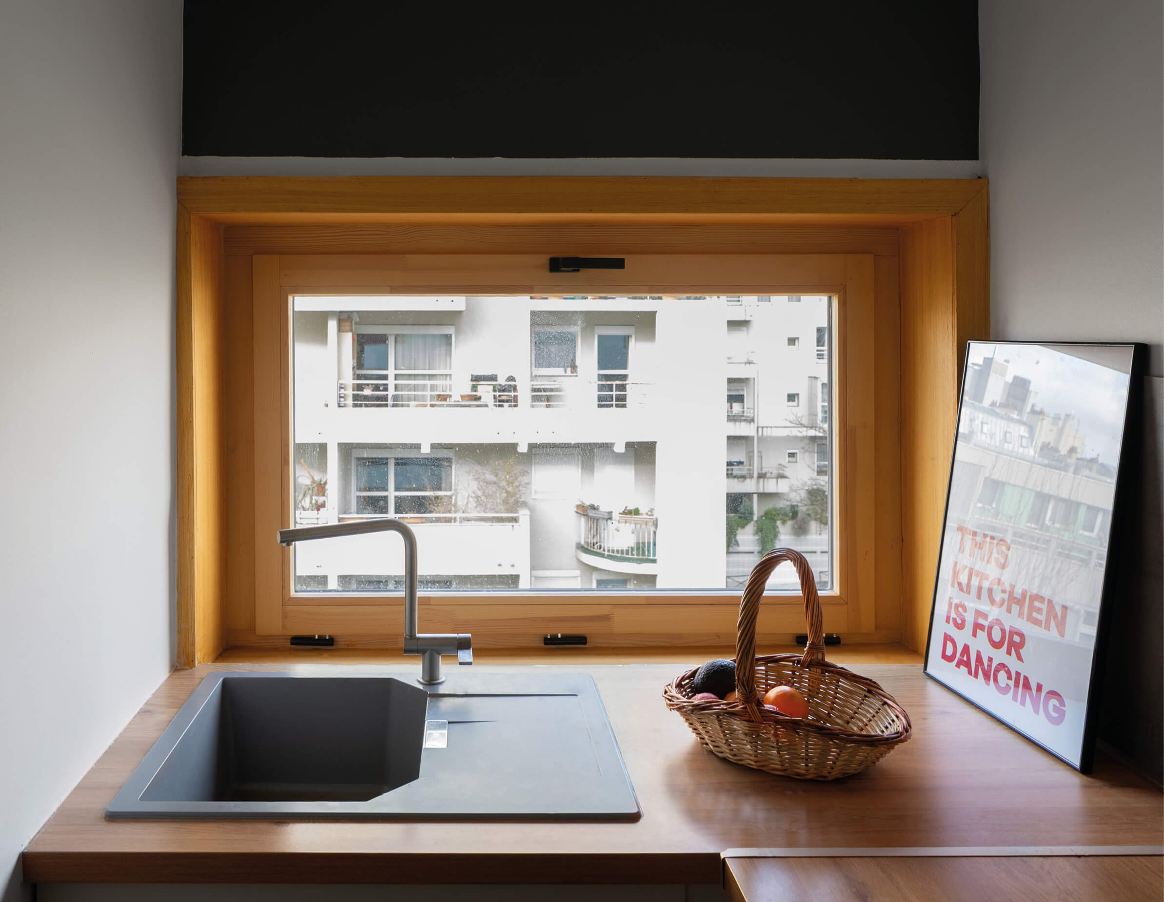 Photo la nouvelle fenêtre de la cuisine, derrière l'évier, après réhabilitation énergétique en milieu habité Impasse Delépine à Paris.