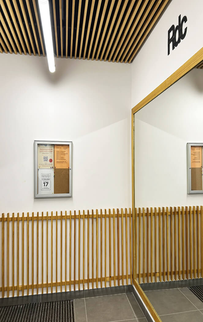 Photo à l'intérieur de l'immeuble de l'impasse Delépine après réhabilitation énergétique au niveau du rez de chaussée montrant les pièces en bois sur le plafonds et une cloison.