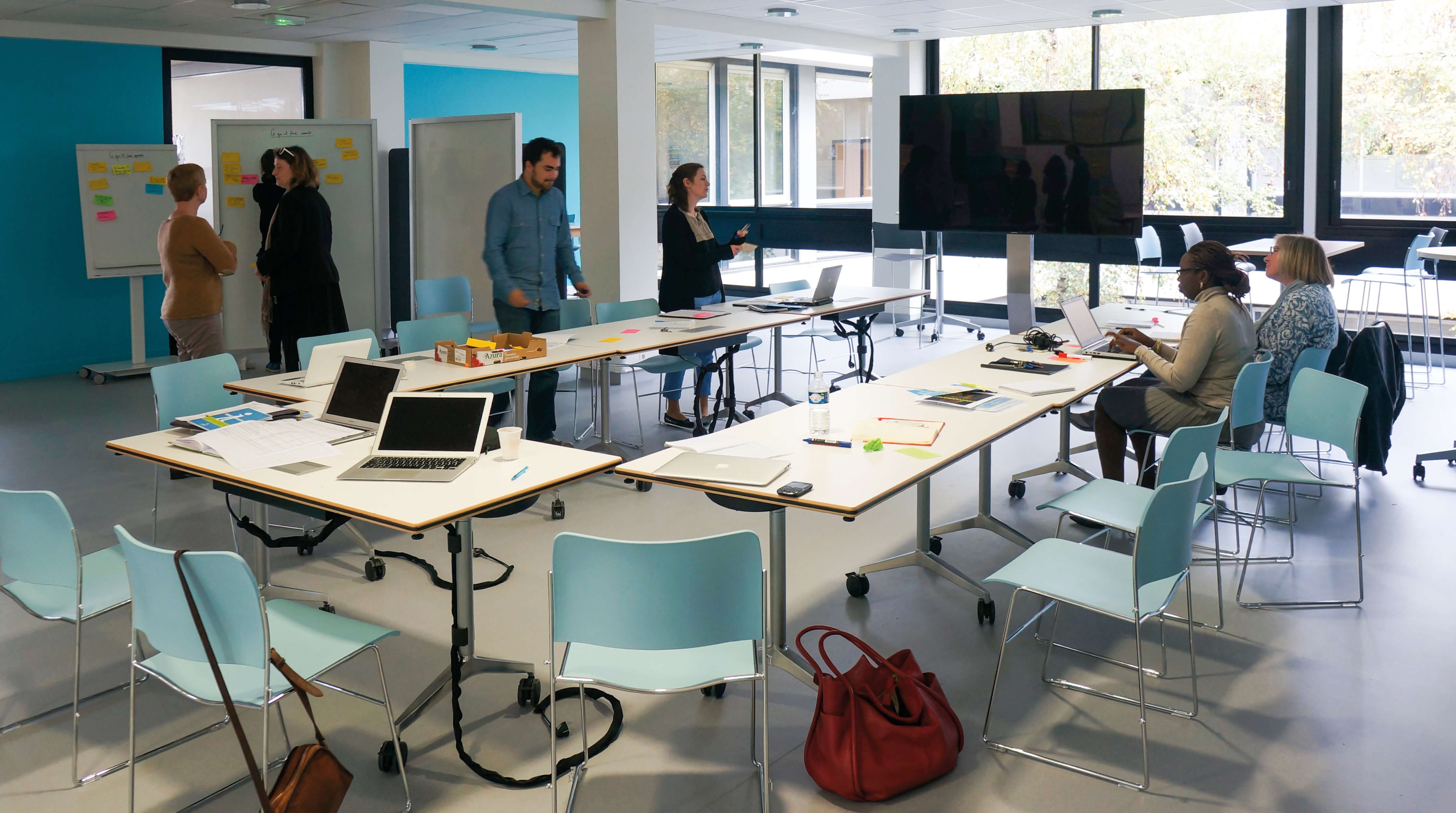 Photo de personnes dans la salle modulable du K-Lab de l’Essec transformée en salle de réunion.