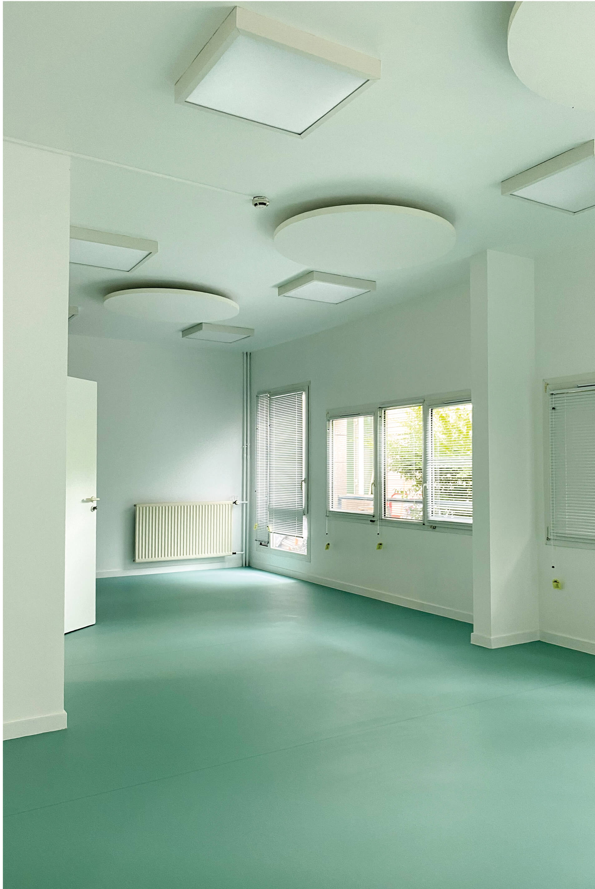 Photo d’une pièce rénovée, lumineuse, avec sol vert et murs dans une déclinaison plus claire, après le réaménagement des espaces communs de l’Ehpad La Citadine de Massy