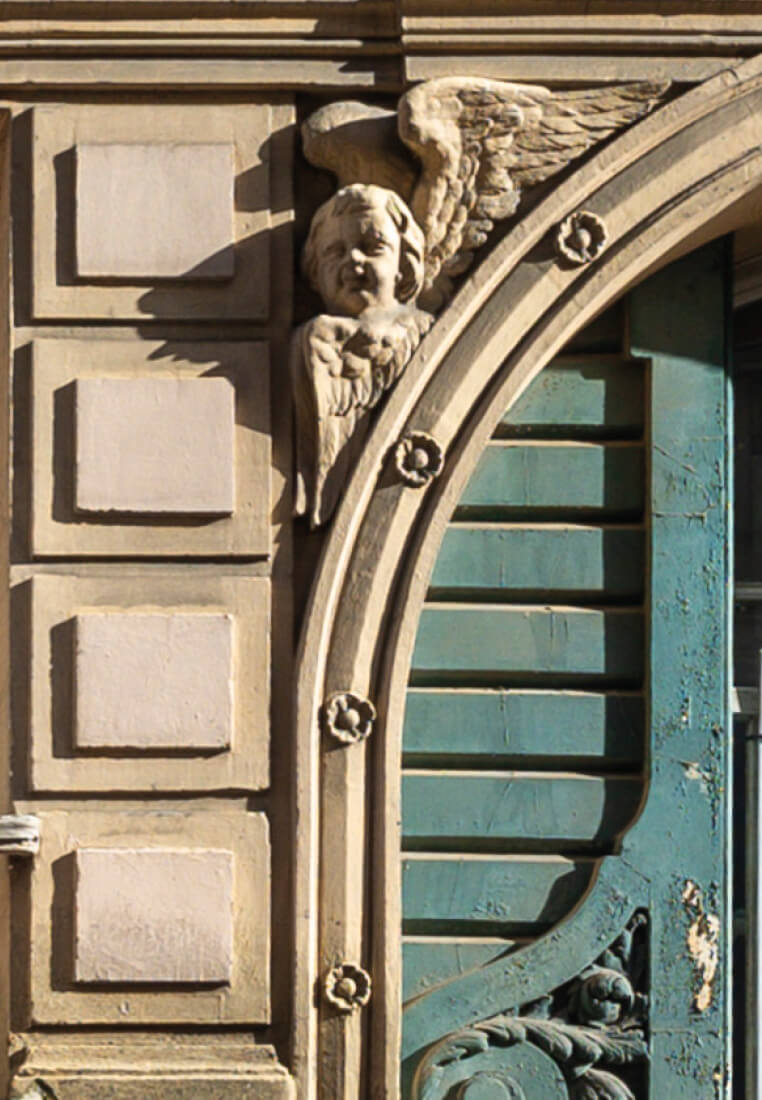 Photo d'un ange sculpté au-dessus de l'arche de l'entrée sur la façade de l'immeuble rue Caplat avant restructuration et réhabilitation du bâtiment.