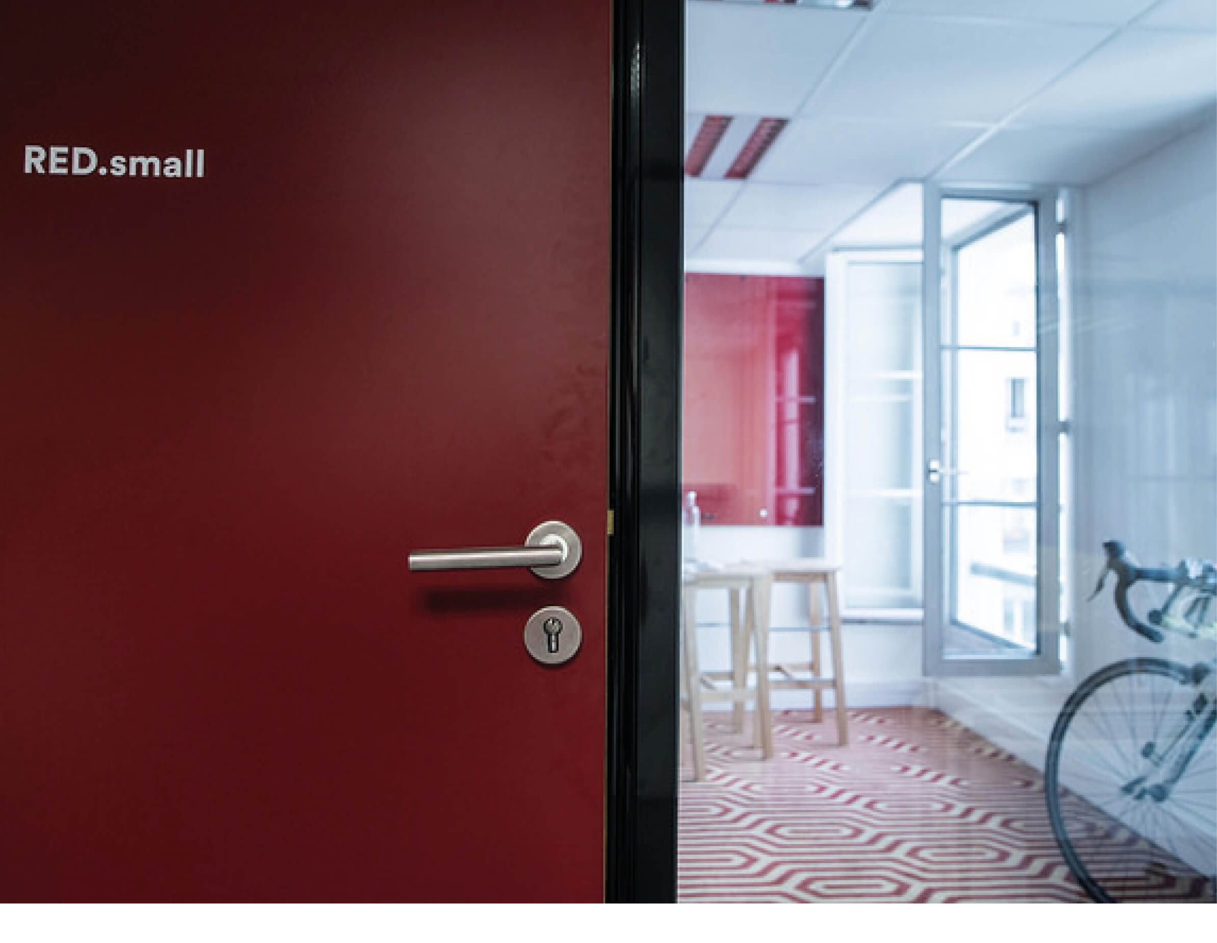 Photo d’une porte d’un espace de travail après l’aménagement Schoolab pensé dans des tons rouges.