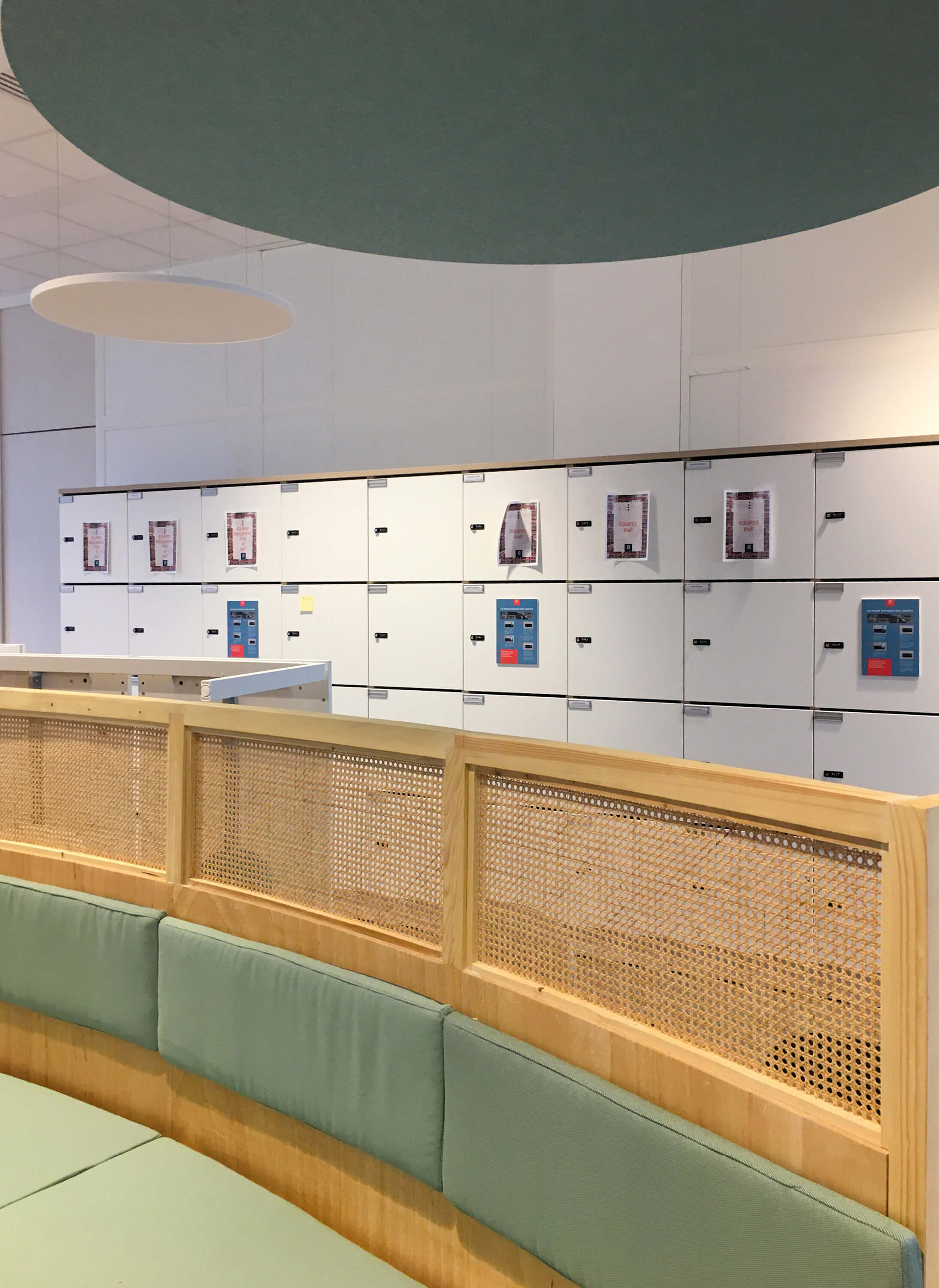 Photo de l’espace conversation avec une longue banquette et des casiers sécurisés à disposition du personnel pour entreposer leurs effets après réaménagement du siège social de la société Iqera