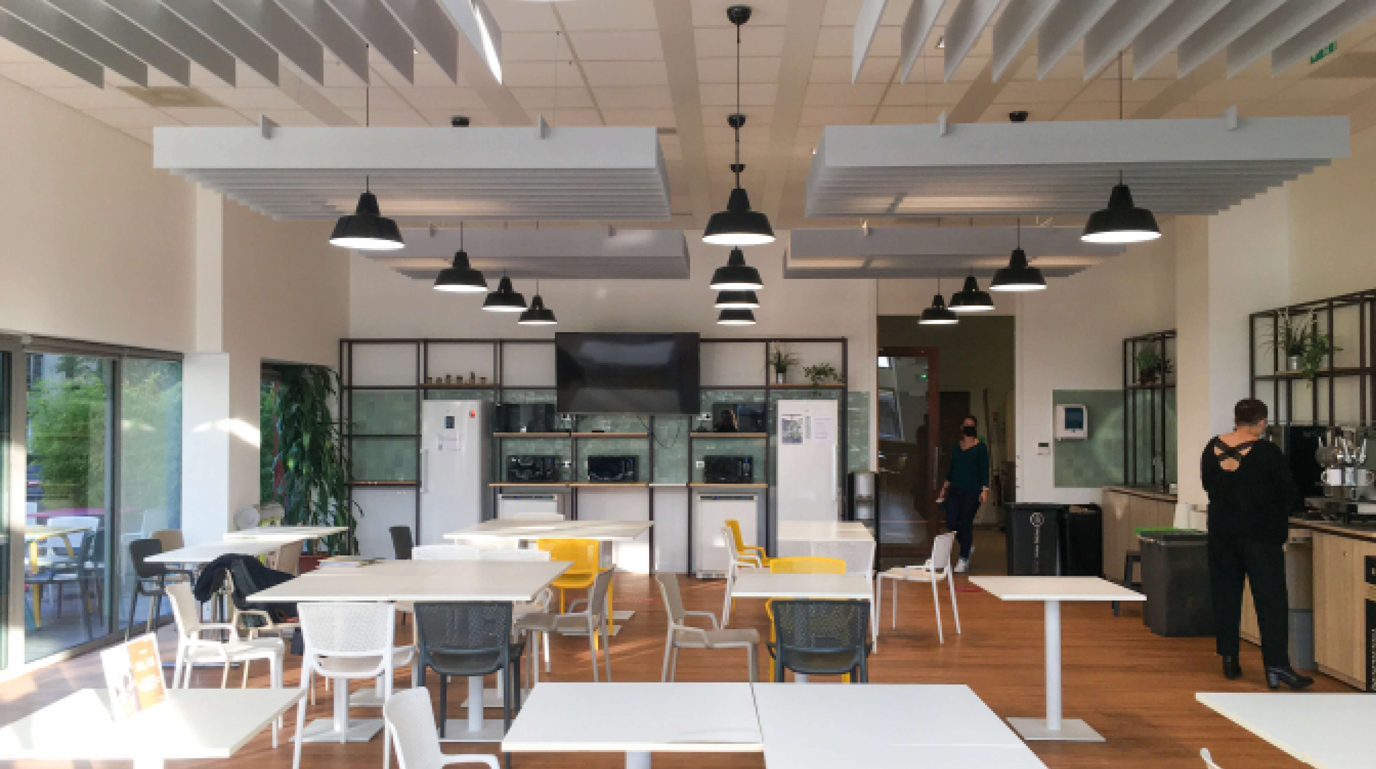 Photo des tables et de l’espace réfrigérateurs et micro-ondes de la salle déjeuner après le réaménagement du siège social de la société Iqera