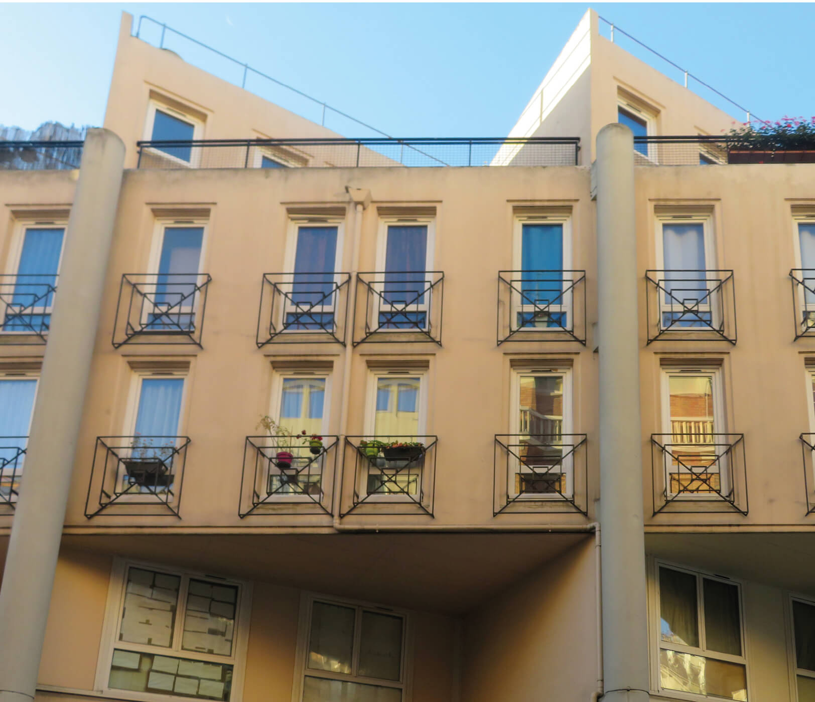 Photo en contre-plongée, avec ciel bleu en fond, de la façade de l’immeuble de la rue de Fontarabie avant réhabilitation énergétique plan climat