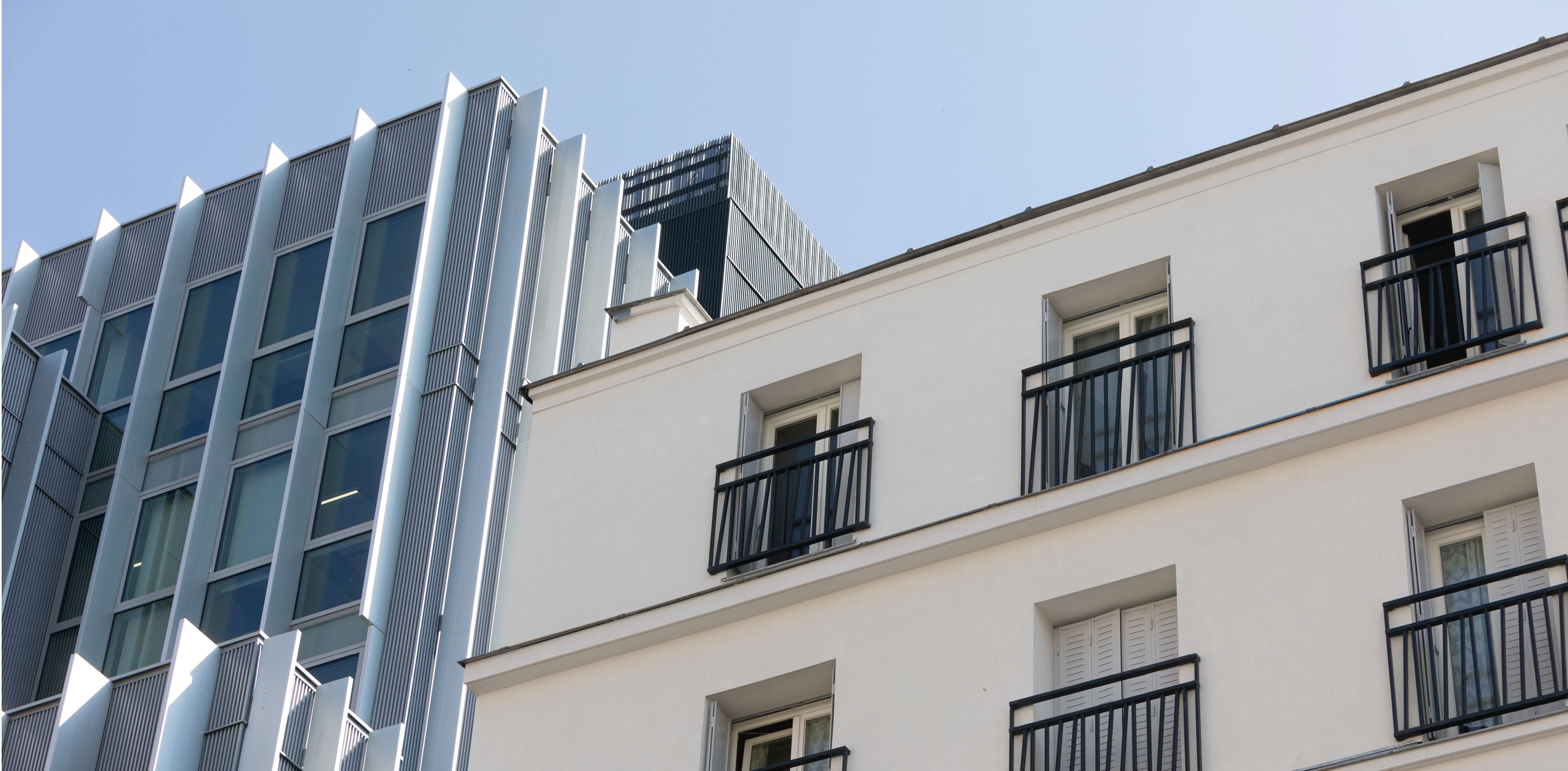 Photo du dernier étage de l’immeuble habité concerné par le projet de réhabilitation plan climat rue Jeanne d’Arc et d’une partie de l’immeuble voisin sur fond de ciel bleu