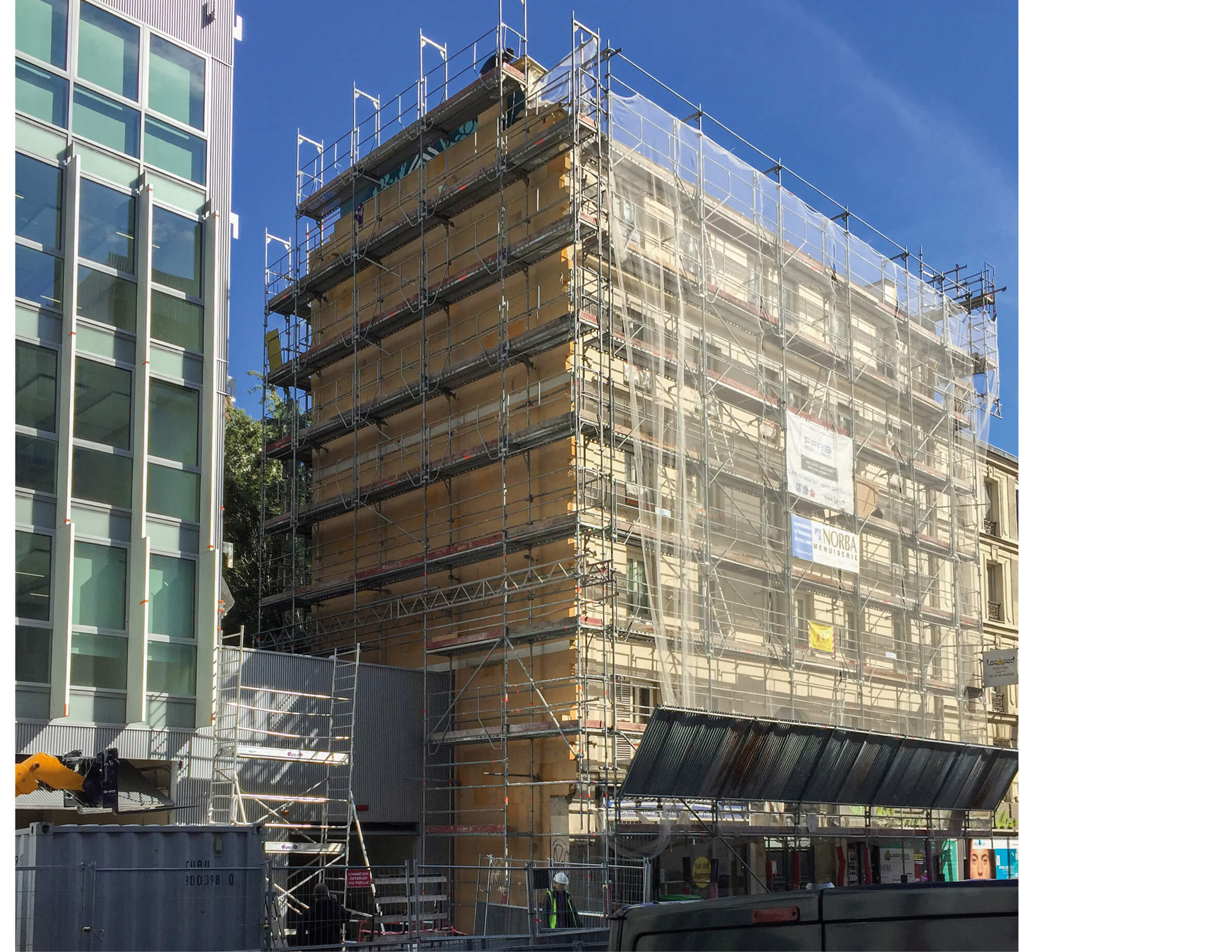 Photo montrant l’échafaudage du projet réhabilitation plan climat en milieu habité rue Jeanne d’Arc sur la façade et la fresque d’Obey