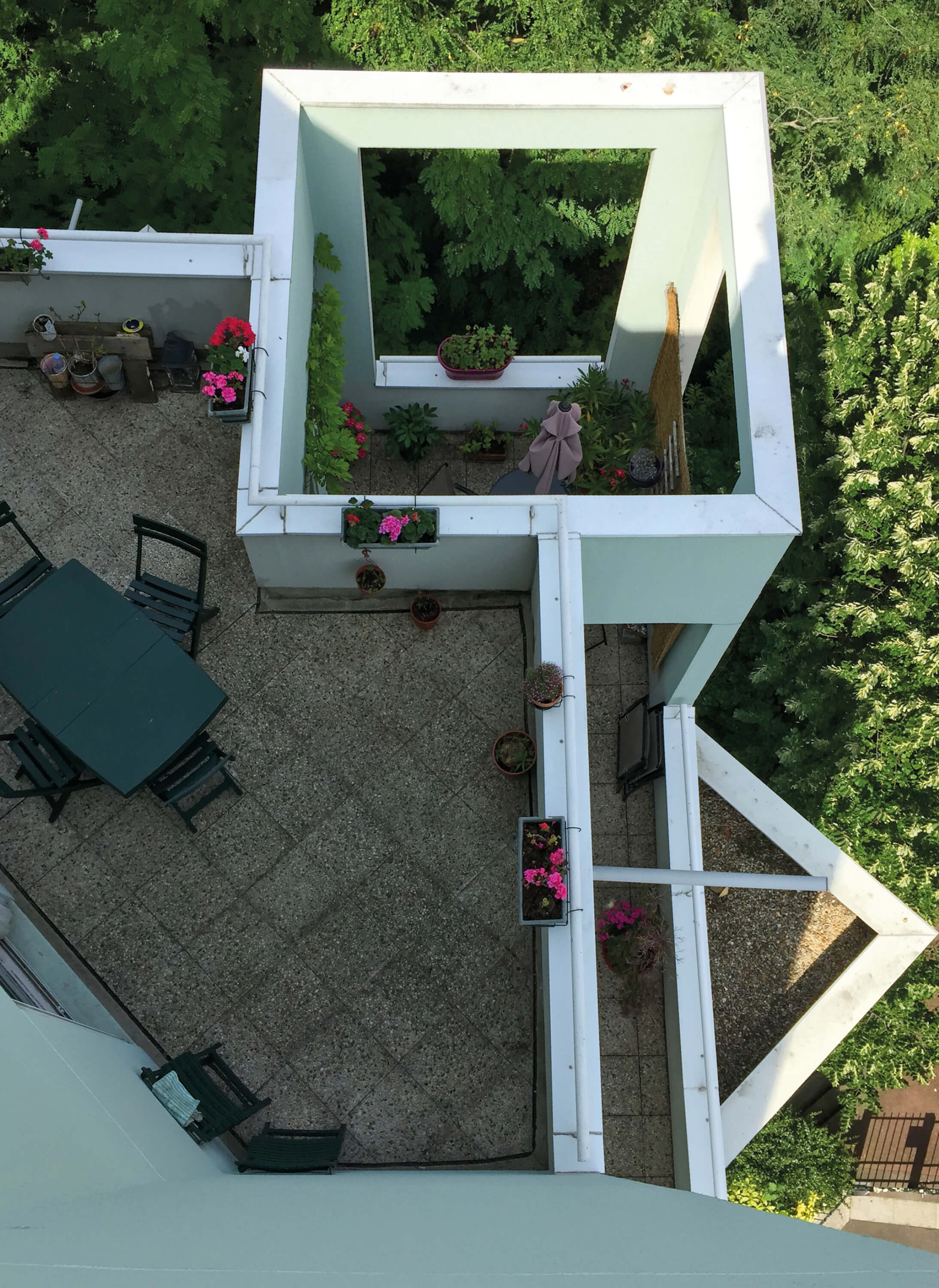 Photo vue plongeante sur une terrasse et un balcon décorés de plantes dans le bâtiment concerné par le concours pour la rehabilitation plan climat rue kergomard