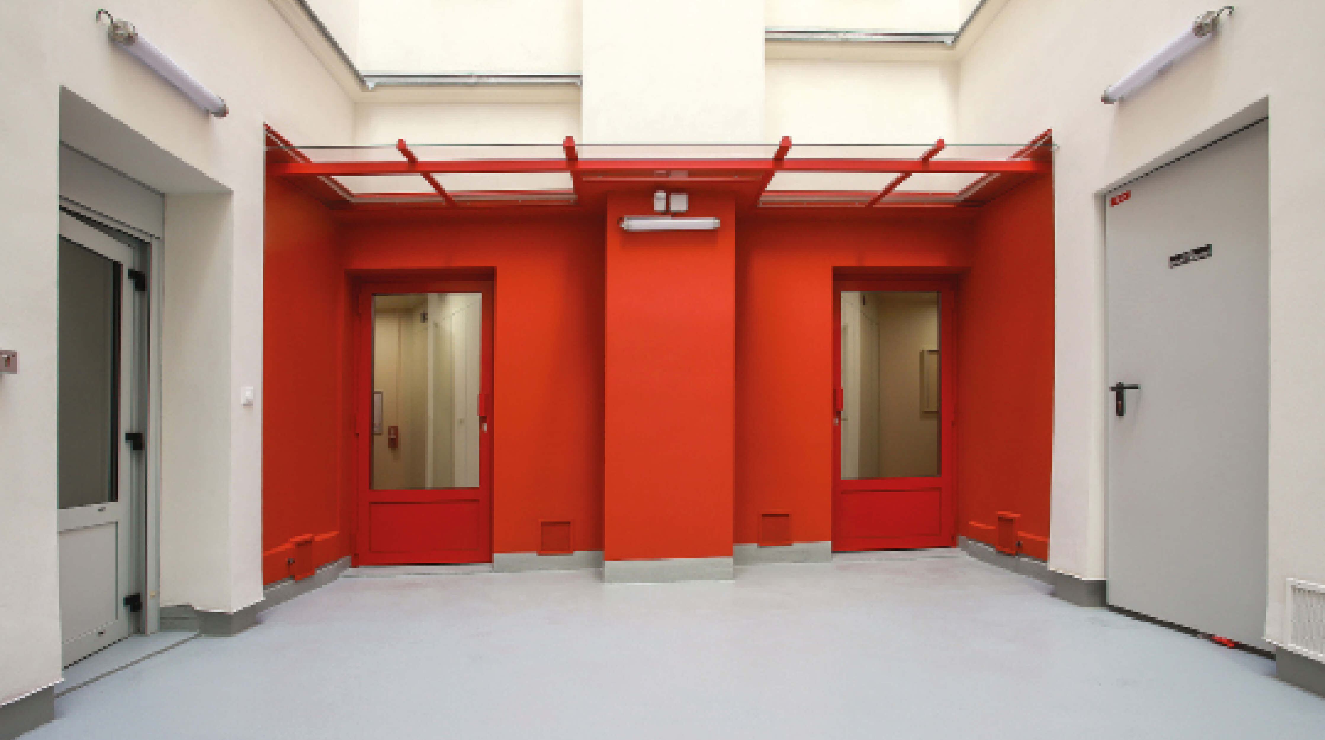 Photo de deux portes d’accès aux parties communes peintes en rouge après restructuration et réhabilitation