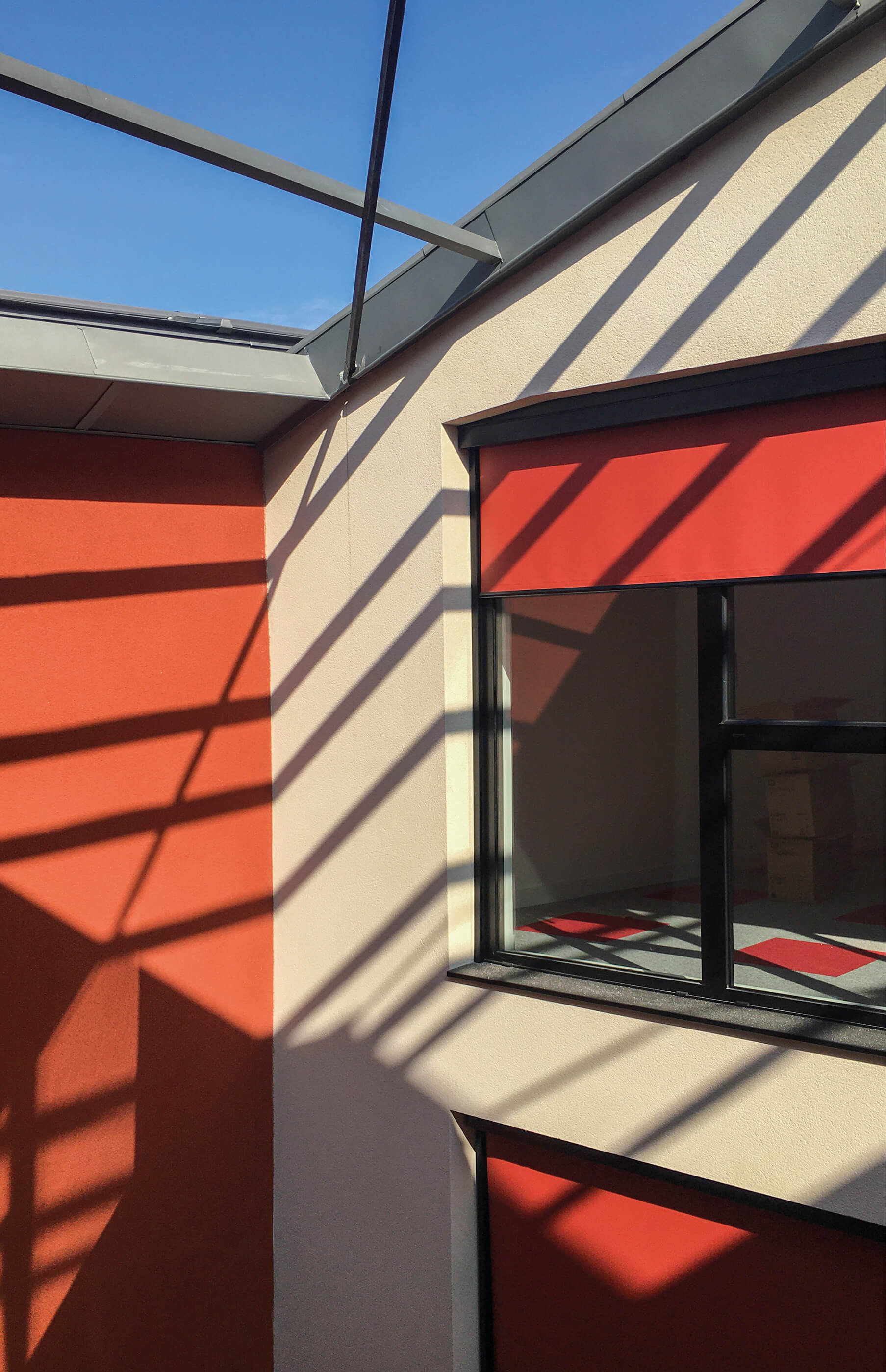 Photo d'une fenetre au store rouge et d'une partie de la verriere renovee apres la reconversion en bureaux