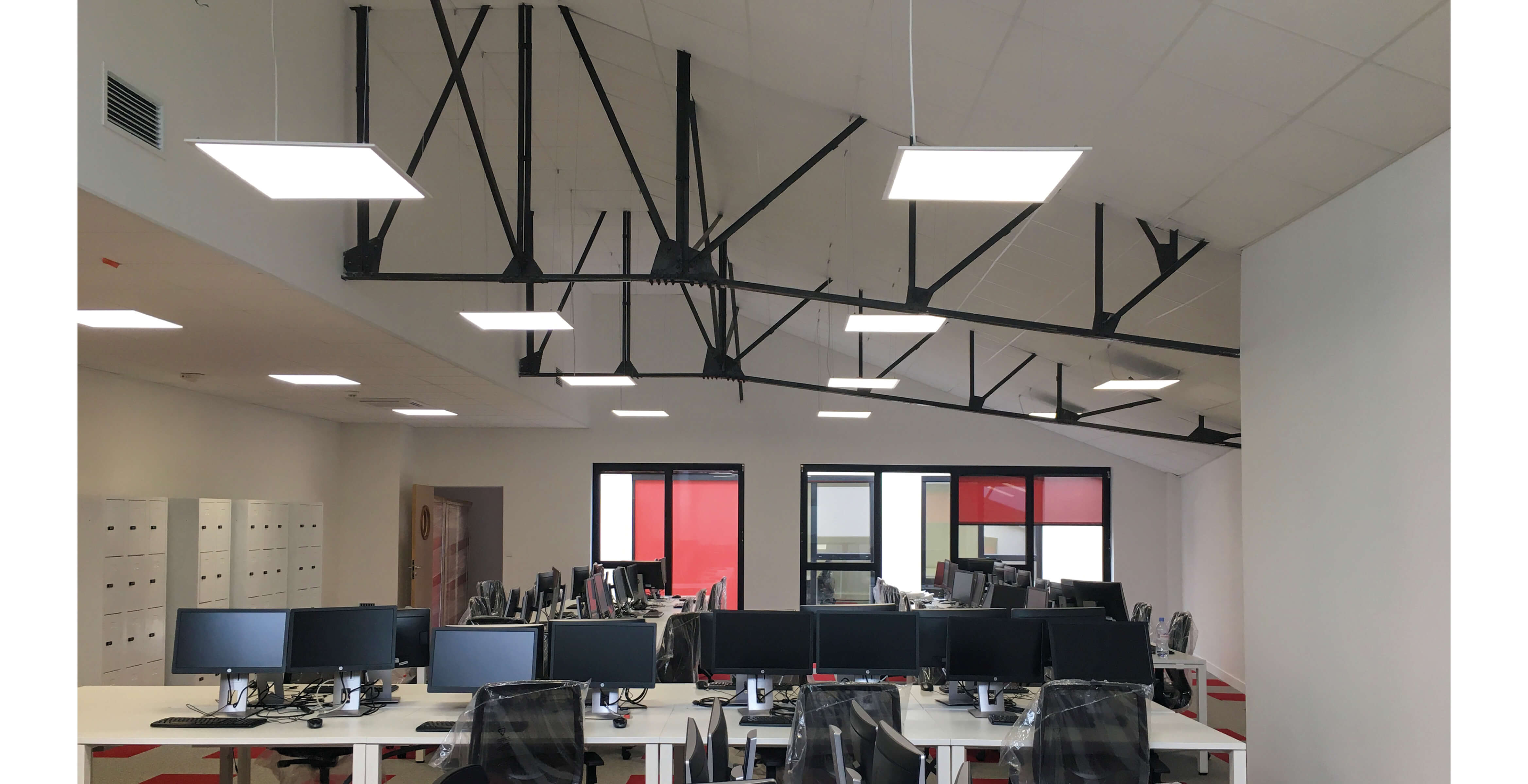 Photo d'un open space avec casiers de rangement et postes de travail equipes d'ordinateurs apres la reconversion en bureaux